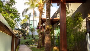 Un sendero de madera que conduce a un área techada con palmeras y bambú.