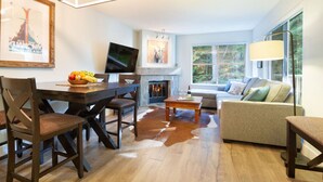 A modern living room with a fireplace, a television, and a sofa. - Mountainside 2Br/2Ba - Hot Tub/Pool/Free Parking (Whistler)