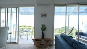 Ein modernes Wohnzimmer mit einer Couch, einem Esstisch mit Stühlen und einer Topfpflanze.