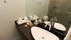 A bathroom with two sinks, a mirror, and neatly arranged towels. - Discover the cozy Napoli Suite in the heart of downtown Saugatuck, a charming retreat for two. (Saugatuck)