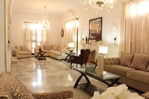 A spacious living room with a large sofa set, a coffee table, and a fireplace. - Luxury Castle in Miramar - PLF24 (Havana)
