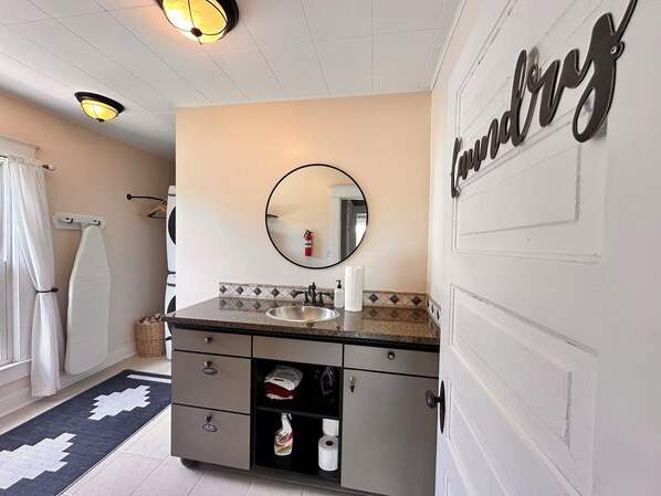 A bathroom with a sink, mirror, towel rack, and storage cabinet. - Welcome to Dacha! Long term winter rental now available! (Spring Lake)