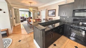 Een moderne keuken met donkere kastjes, een centraal eiland en een inbouwoven.