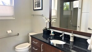 A modern bathroom with a toilet, sink, and vanity.
