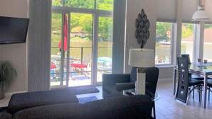 A spacious living room with a large sliding glass door leading to an outdoor area with a pool and tables.