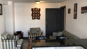 A modern living room with striped sofas, a wooden coffee table, and a dark door. - Excellent location and comfort near La Carolina Metro Station (Quito)