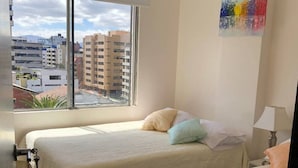 A hotel room with two beds, a window with a city view, and a painting on the wall. - Excellent location and comfort near La Carolina Metro Station (Quito)