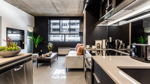 A modern kitchen with a built-in oven, a dishwasher, and a large window providing natural light.