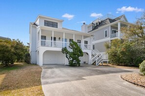 A two-story house with a covered porch, a garage, and a staircase leading to the upper level.