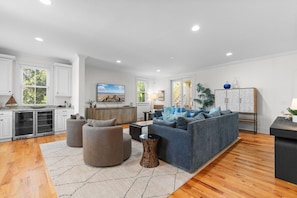 A spacious living area with a sofa, armchairs, and a coffee table.