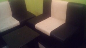A room with two black sofas and a small black table. - Desai Villa (Nairobi)