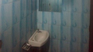 A bathroom with blue patterned tiles, a bidet, and a mirror. - Desai Villa (Nairobi)