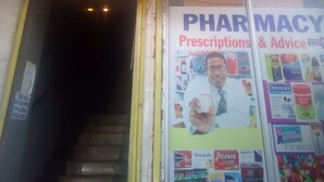A sign for Desai Villa Bar & Restaurant with an entrance and a pharmacy sign advertising prescriptions and advice. - Desai Villa (Nairobi)