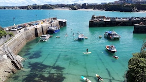 A coastal harbor with boats, docks, and a clear view of the surrounding landscape.