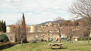 Un pueblo rural con edificios de piedra, una mesa de picnic y cielo despejado.