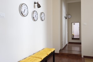 Guests can sit on the bench in this hallway, surrounded by four unique wall clocks.