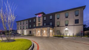 Um hotel de vários andares com fachada de pedra e letreiros iluminados.