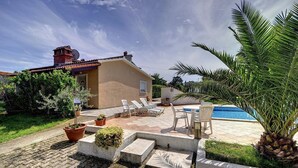 A patio with outdoor seating, a swimming pool, and a small garden area with potted plants. - Apartment with pool and only 700 meters to sandy beach (Medulin)