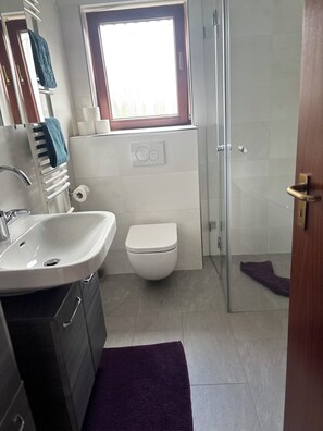 Een bad, een haardroger, handdoeken, toiletpapier