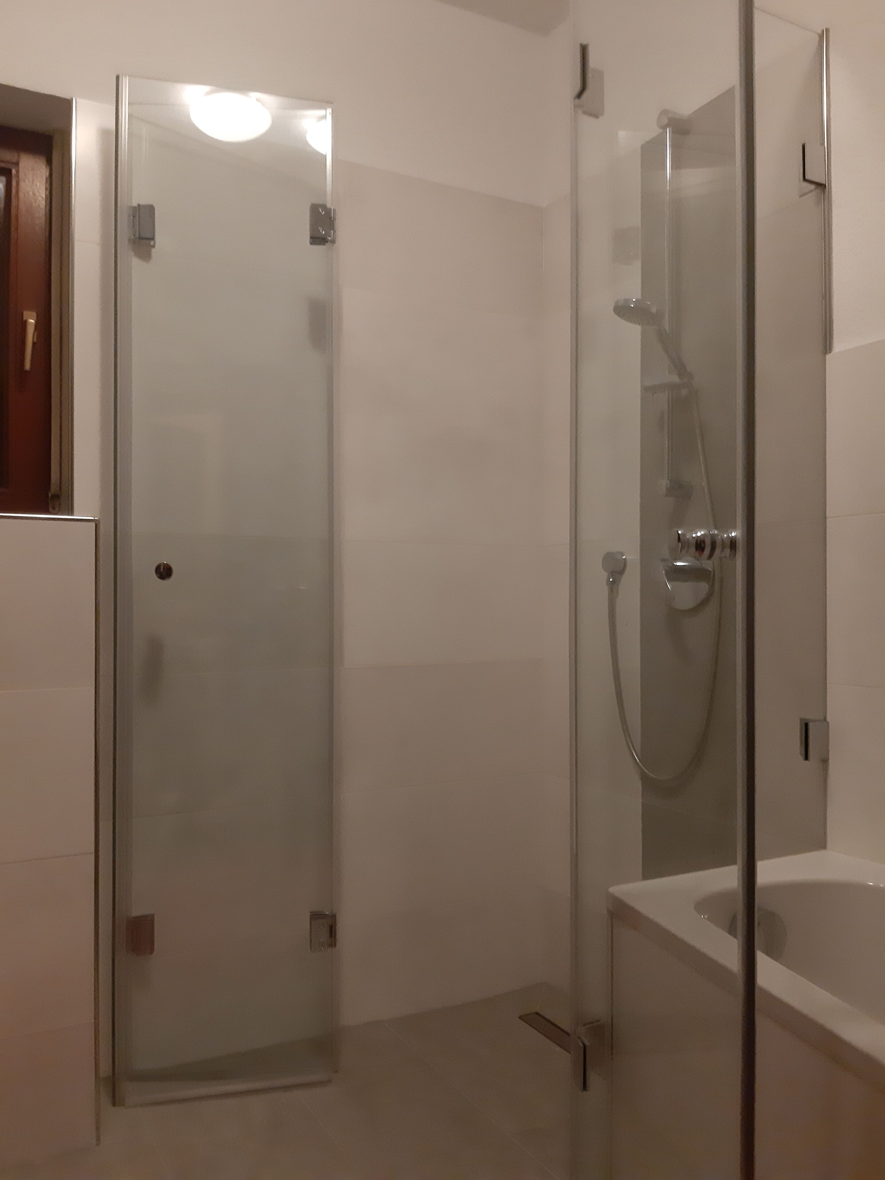 Une salle de bain moderne dotée d’une douche à parois de verre, d’une baignoire et de toilettes.
