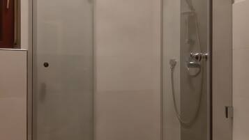 Une salle de bain moderne dotée d’une douche à parois de verre, d’une baignoire et de toilettes.