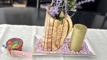 Una mesa con un jarrón decorativo, una vela y un cuenco pequeño.