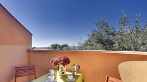 A small outdoor dining area with a table set for two, a vase of flowers, and a coffee pot. - Just 100 meters to beach and sea view (Medulin)
