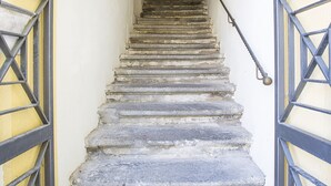 Una escalera con barandilla de metal que conduce a un arco en la parte superior.
