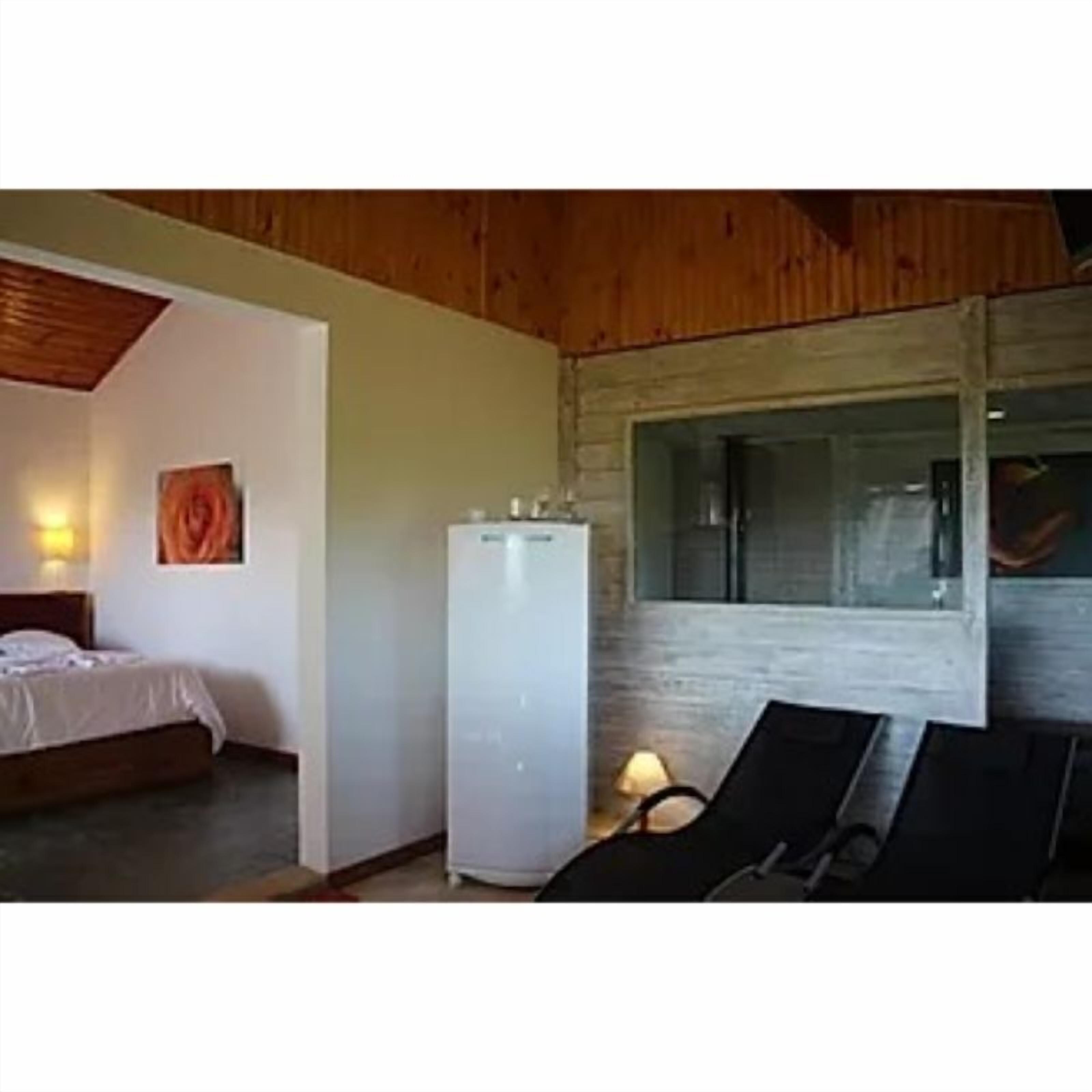 A bedroom with a bed, a white wardrobe, and a window.