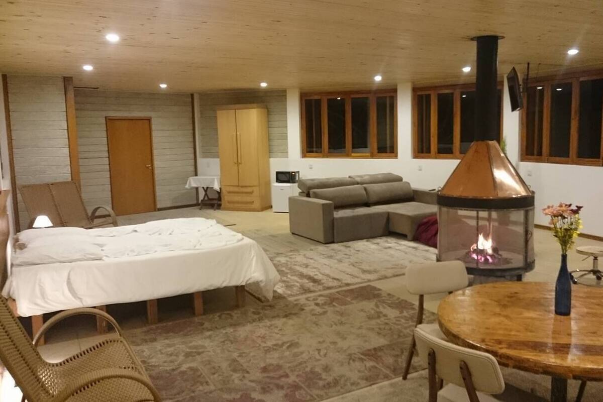Une pièce confortable avec un lit, un canapé et une cheminée.