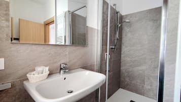 Habitación básica doble | Baño | Regadera, amenidades de baño gratuitas, secadora de cabello, toallas