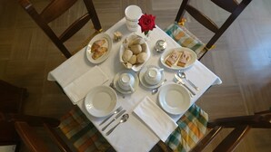 A dining table set with plates, bowls, a teapot, and a rose. - Hotel da Marco (Vigo di Cadore)