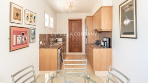 A compact kitchen with wooden cabinets, a coffee machine, and a microwave. There is a door leading to another room, and a framed picture on the wall. - Wonderful villa with country views, private pool, sleeps 6, AC (Binixica)