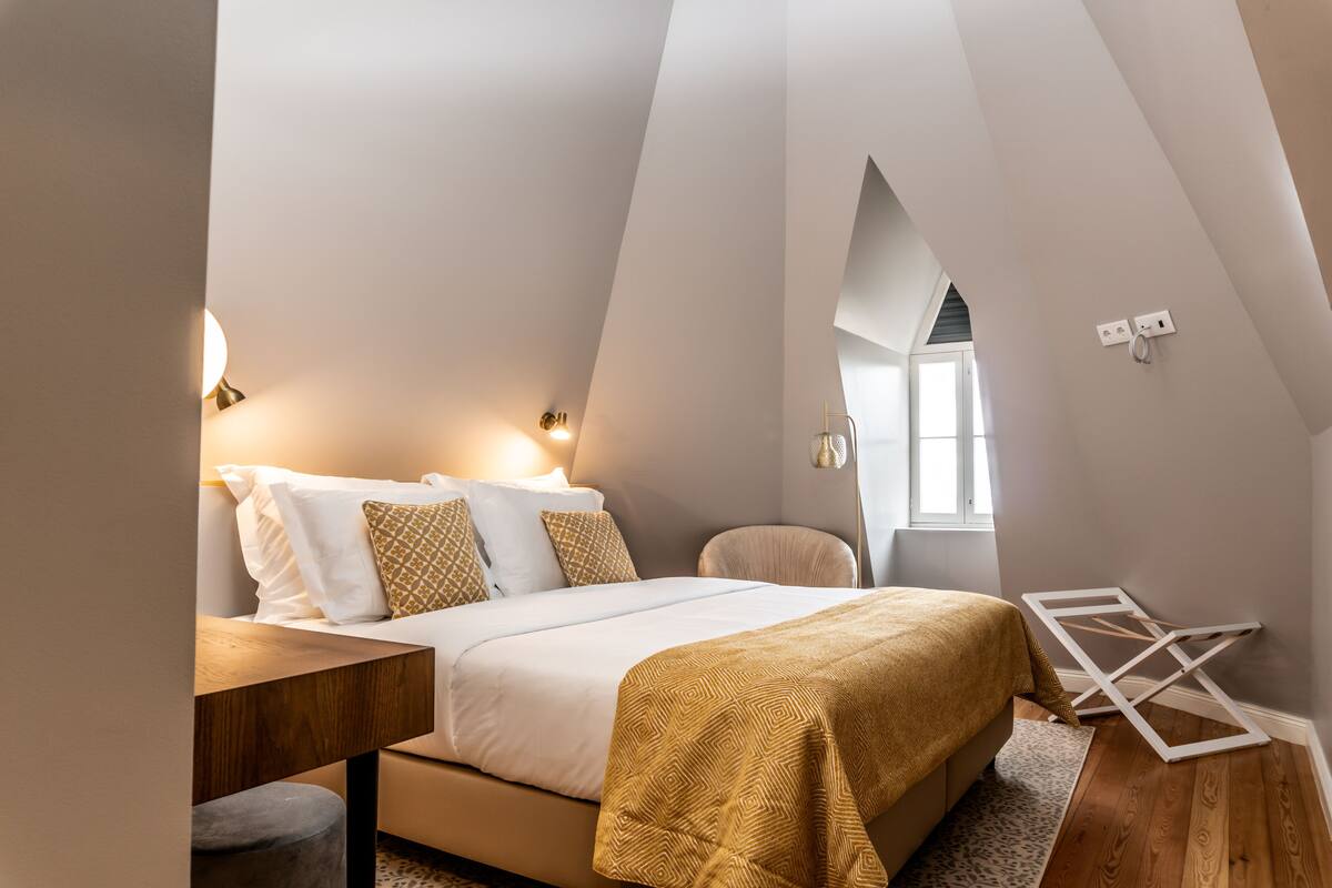A bedroom with a bed, bedside tables, a chair, and a window.