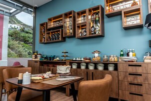 Una cocina moderna con armarios de madera, un comedor con sillas de cuero y vistas a una colina.