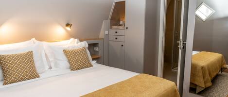 A bedroom with a bed, bedside tables, a wardrobe, and a mirror.