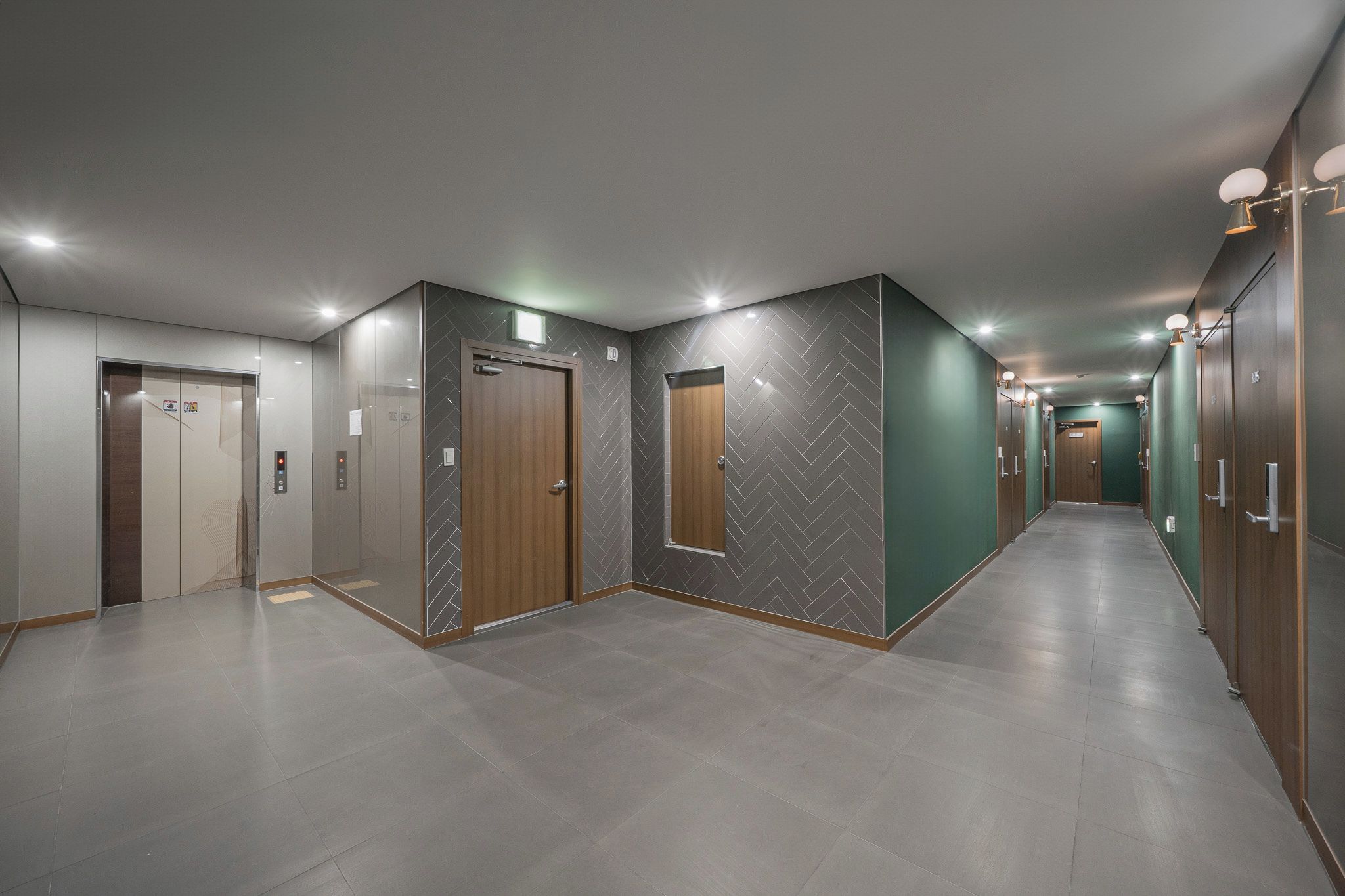 A corridor with a series of doors, some with glass panels and others with wooden doors, leading to different rooms.