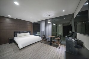 A modern hotel room with a large bed, a desk with a computer, a chair, and a small table. - H Moment Hotel in Yangsan (Yangsan)