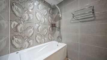 Un baño moderno con bañera, ducha y barra para toallas.