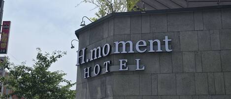 A building with a sign that reads 'H.moment HOTEL'.
