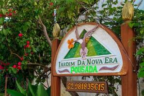 A sign with a bird illustration and text for 'Jardim Da Nova Era Pousada'.