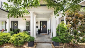 A house with a front porch, columns, and a black door. - Wright Place - Walk to Downtown - 0.5 mi to UofA (Fayetteville)