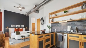 A modern kitchen with a brick backsplash, wooden cabinets, and a built-in oven. - The Axis - Condo on Dickson St - Walk to UofA (Fayetteville)