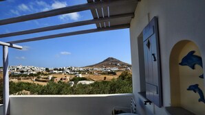 A balcony with a view of a town and a mountain.