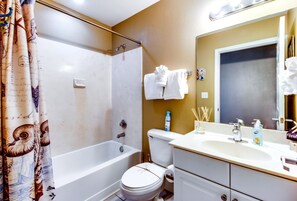 A bathroom with a bathtub, toilet, and sink. - Tidewater by Forehand Rentals (Panama City Beach)