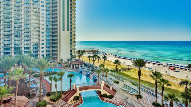 A high-rise hotel with a pool area, beach access, and a view of the ocean. - Shores of Panama by Forehand Rentals (Panama City Beach)