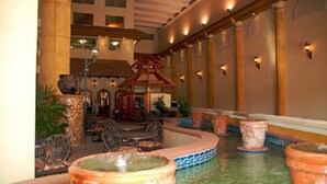 An indoor courtyard with a fountain, seating area, and a small gazebo. - Shores of Panama by Forehand Rentals (Panama City Beach)