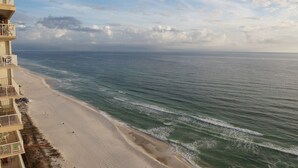 A beachfront hotel with a sandy beach and ocean view.