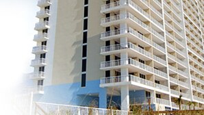 A high-rise hotel with multiple balconies and a beach view.
