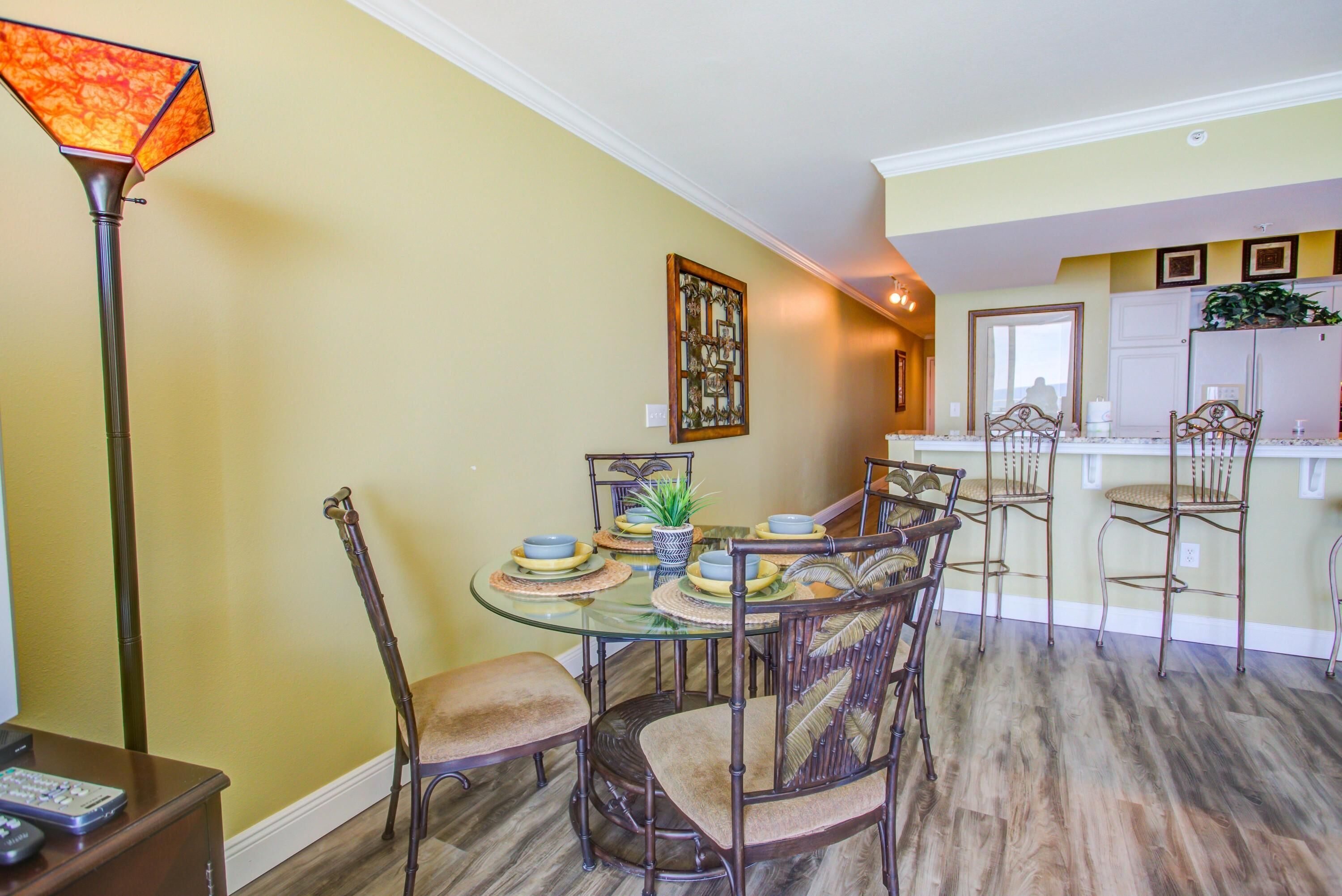 A dining area with a glass table, metal chairs, and a decorative lamp.